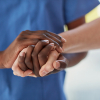 A healthcare professional holding someone's hand